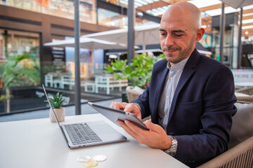 A cryptocurrency trader monitors the market with his tablet