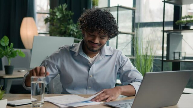 Angry furious Arabian Indian man working at office crumpling paper breakdown stress male businessman frustrated with mistake in report throwing crumpled sheet business failure no ideas wrong document