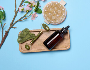 Brown glass bottle for cosmetics, brush for dry body massage on a black background, top view