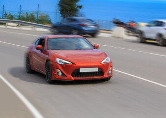 Red sports car rushes along the highway