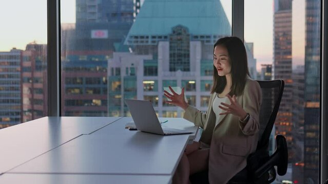 Young happy Asian woman executive leader or hr manager having remote video conference call meeting communicating by videocall on job interview working on laptop in modern office.
