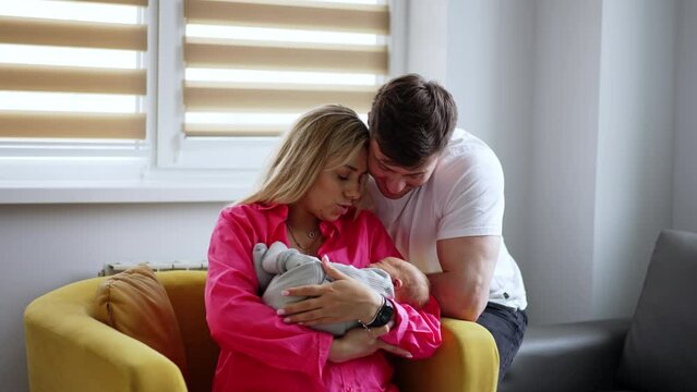 Loving new-made parents with their child. Couple swaying their baby in maternity hospital ward.