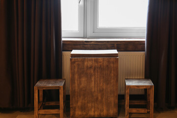 Wooden chairs and table near window in hotel room