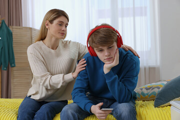 Mother comforting her upset teenage son at home