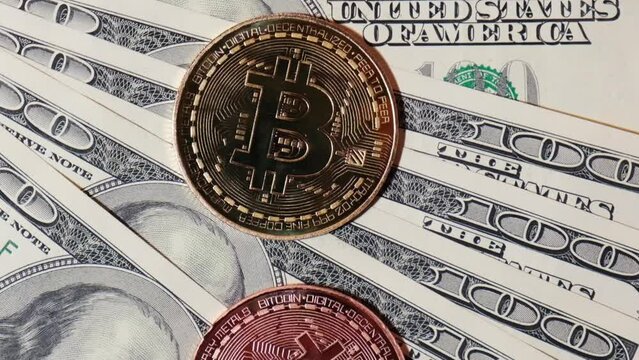 Bitcoin gold coin on bills of 100 dollars. Bitcoin mining trading concept. BTC golden money spinning around. Worldwide virtual internet Cryptocurrency or crypto digital payment system. Digital coin