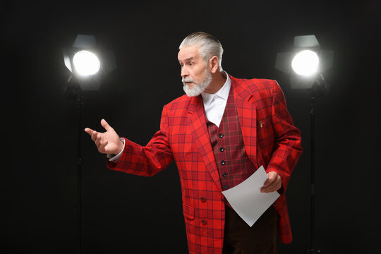 Senior actor with script performing on stage