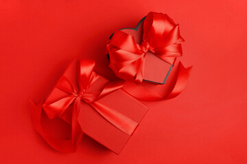 Beautiful gift boxes with bows on red background, flat lay