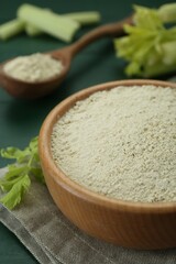 Natural celery powder and fresh stalks on green table, closeup