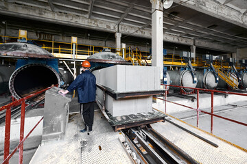 Worker loads raw blocks into open tanks for hardening