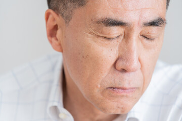 目を閉じる高齢者男性