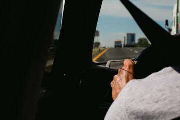 Person in grey sweater driving car