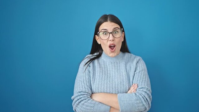 Young hispanic woman smiling with thumbs up over isolated blue background
