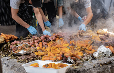 A group of cooks set aside the meat and vegetables prepared underground as a part of the curanto ceremony. Colonia Suiza, Bariloche, Argentina.