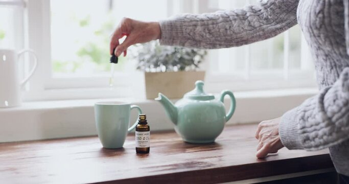 Morning, hands and woman with tea oil for wellness, health and a home detox. Relax, medicine and a lady with cannabis in a cup of coffee for healthcare, natural remedy and an herbal treatment