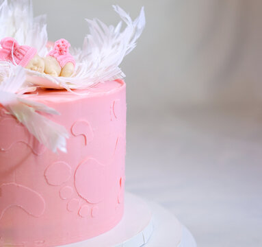 decoration of a cake for a family christening pink cake with footprints of small child on top of angel wings and baby in pink diaper a girl how to find out gender of child with help of a cake