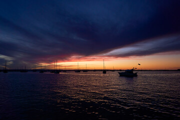 Sunset with a deep blue and orange sky with yachts and sailboats in the marina harbor of La Paz, Baja California Sur.