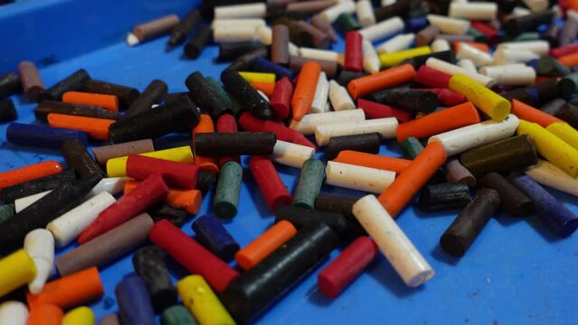 Colorful pile of broken crayons without paper on a blue surface