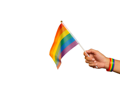 Rainbow flag and wristband in hand against a transparent background