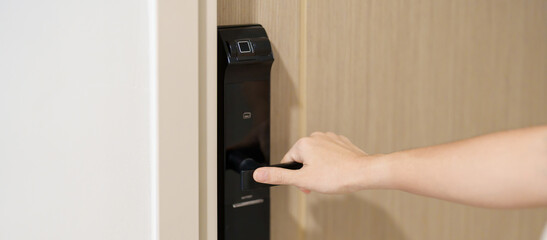 Hand using smart digital door lock while open or close the door at home or apartment. NFC Technology, Fingerprint scan, keycard, PIN number, smartphone, electrical and contactless lifestyle concepts