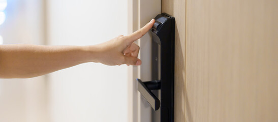 Fototapeta na wymiar Hand using fingerprint scan for smart digital door lock while open or close the door at home or apartment. NFC Technology, keycard, PIN number, smartphone and contactless lifestyle concepts