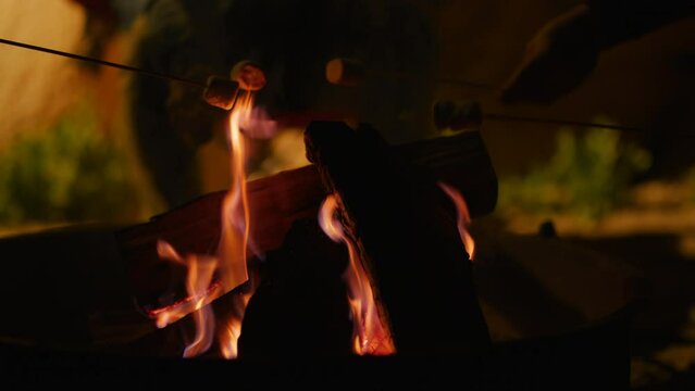 Close-up view of people making Marshmello over the fire and the campground in Joshua tree Park. California. Slow motion high-quality 4K footage shot on red