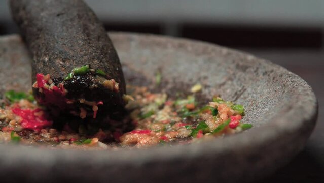 Close up the chef is pounding chili sauce. Sambal is a famous food from Indonesia