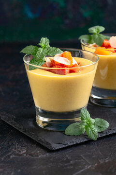 Creamy peach dessert with peach pieces and mint.