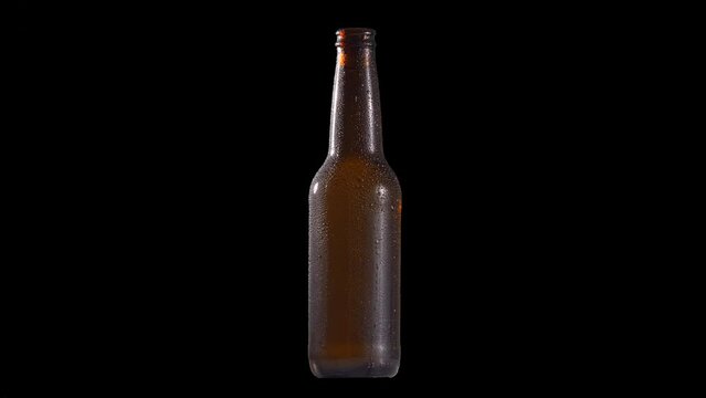 Spinning beer bottle ambar glossy wet humid drops detail for background replacement black background