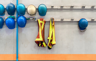 Safety vest and construction hardhat of supervisors and employees hang in front of the factory office shop for safety. Concept of work safety. Building industry.