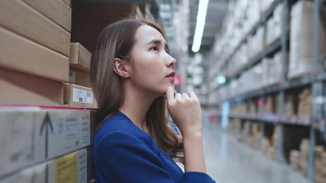 Asian female looking, thinking management inventory in factory system concept.