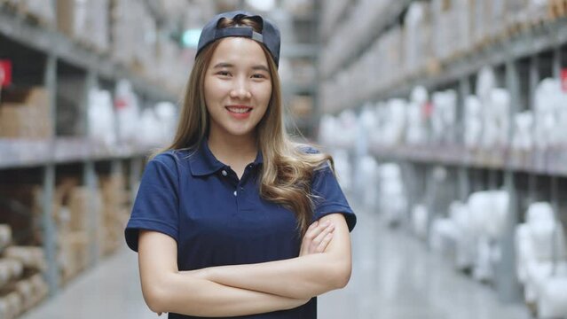 Portrait of Asian female smiling while standing in warehouse factory. 