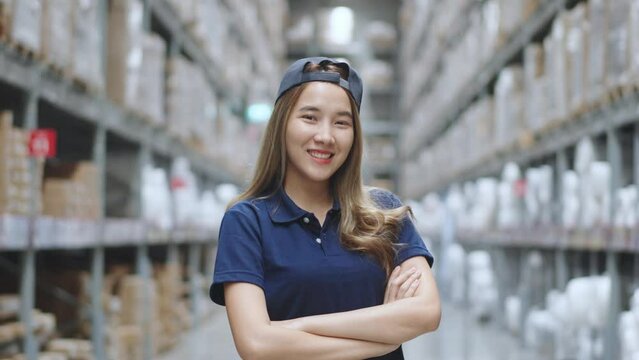 Portrait of Asian female smiling while standing in warehouse factory. 
