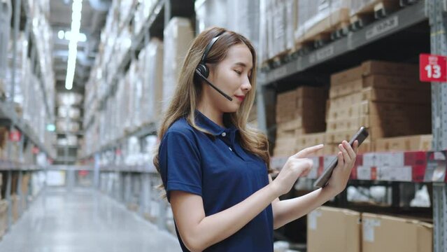 Asian female using tablet checking amount of stock product inventory on shelf at distribution warehouse factory. logistic business shipping and delivery logistic service.