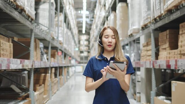 Asian female using tablet checking amount of stock product inventory on shelf at distribution warehouse factory. logistic business shipping and delivery logistic service.