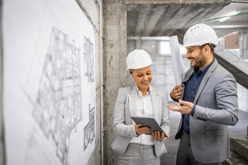 Two experienced architects working together on the new project at construction site.