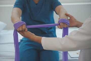 Doctor or Physiotherapist working examining treating injured arm of athlete male patient, stretching and exercise, Doing the Rehabilitation therapy pain in clinic.