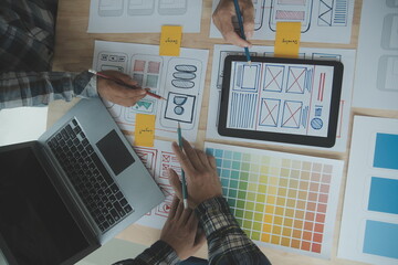 Close up ux developer and ui designer brainstorming about mobile app interface wireframe design on...