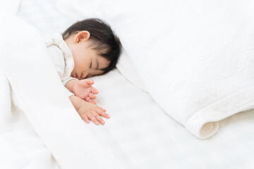 ベッドで昼寝する生後9ヶ月の赤ちゃん