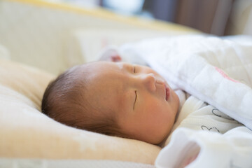 Fototapeta na wymiar ベビーベッドで寝る赤ちゃん
