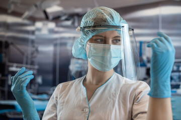 Fototapeta na wymiar Portrait of female surgeon or assistant wearing surgical mask in operating theatre room