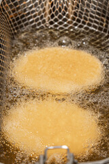 fryer with breaded chicken in boiling oil