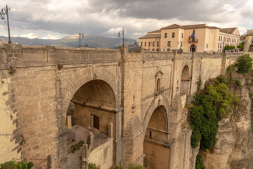 Fototapeta premium new bridge ronda,malaga,spain with the mountain in the background and dramatic cloudy sky