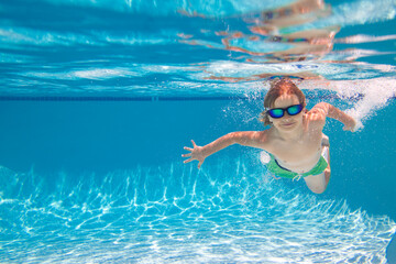 Child in swimming in pool. Funny little boy swims underwater in the pool. Underwater kids portrait from under the water. Summer holiday. Kids weekend. - Powered by Adobe