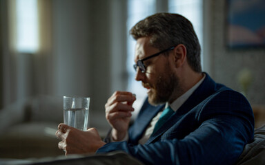 business man has headache taking painkiller. photo of business man with headache painkiller.