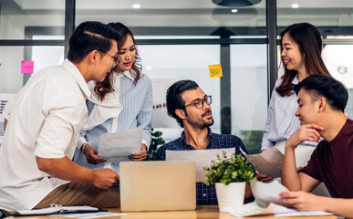 Group of asian business meeting and discussing strategy startup project analysis finance process.Success asian business people work plan and brainstorm marketing idea with laptop in office.Teamwork