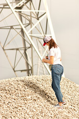 a young female foreman of the white race checks compliance with the protocol requirements during the construction of a power plant, calculates compliance or violations, records in writing