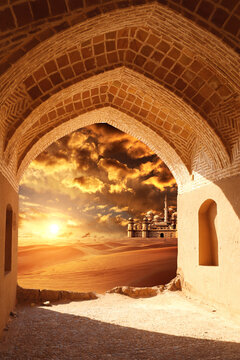 Ancient arch at the entrance to desert. View of sand dunes and fabulous lost city through stone arch. Beautiful desert landscape with sand dunes and mythical oriental castle