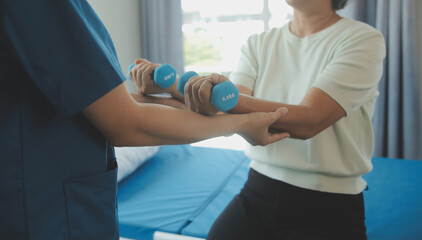 Doctor or nurse or physiotherapist caregiver exercise with senior woman at clinic or nursing home
