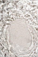 The texture of water on a sand background in bright sunlight.