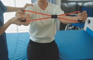 Doctor or nurse or physiotherapist caregiver exercise with senior woman at clinic or nursing home